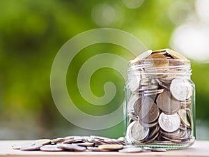 Coins in glass jar on blur background. money saving financial co