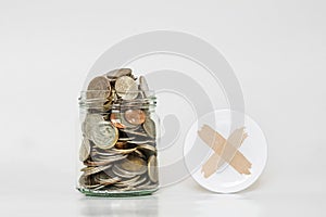 Coins in glass jar, and covered with cross symbol