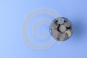 Coins in a glass jar isolated on blue sky background, save money, investment, Thai baht, success life, save, thinking for future.