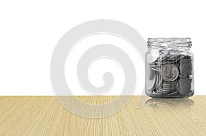 Coins in a glass jar on Wood floor ,savings coins - Investment And Interest Concept saving money concept