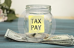 Coins in glass money jar with tax pay