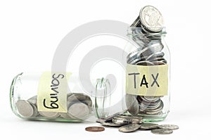 Coins in glass money jar with tax and savings label