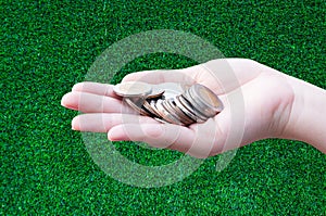 Coins in hands on grass