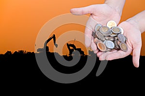 Coins in hands on Industry silhouette Landscape background