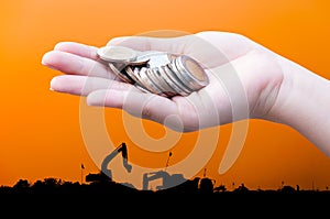 Coins in hands on Industry silhouette Landscape background