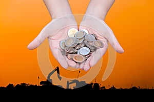 Coins in hands on Industry silhouette Landscape background,Donation Investment Fund Financial Support Charity