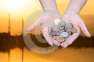 Coins in hands on Industry silhouette Landscape background