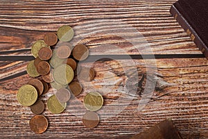 Coins and holy bible book on wooden background with copy space, top view