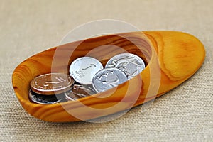 Coins of Israel in denominations of 1 shekel and 2 shekels in handmade wooden shoe