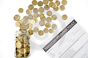 Coins in jar with education insurance policy