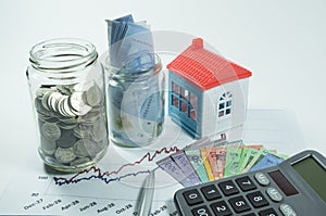 Coins, Jar and House in the background