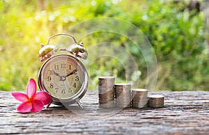 Coins in jar with money stack step growing money and alarm clock