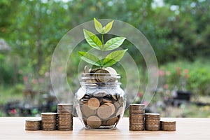 Coins in jar with money stack step growing money.