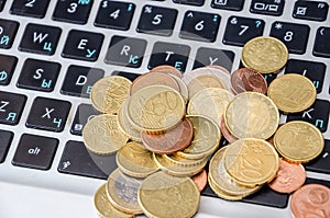 Coins on laptop keyboard close-up. Business concept.