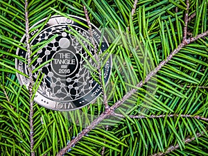 Coins of miota on the branches of spruce. Christmas crypto gift.