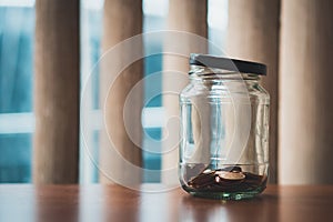 Coins money in glass jar with small amount using as financial an