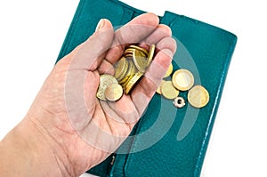 Coins in a palm and a green female purse. White background. Close-up.