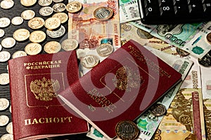 Coins and paper money and two international passports lie on a black wooden table