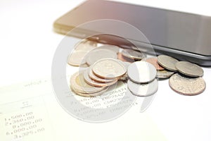 Coins and phone on account book bank for finance and banking.