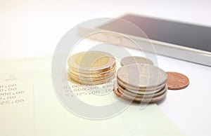 Coins and phone on account book bank for finance and banking.