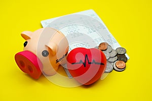 Coins in piggy savings jar, account book, pulse heart rate heart, health insurance, medical expenses, tax concept, financial