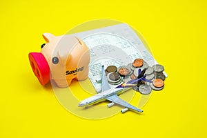 Coins in piggy savings jar, coins, account book, airplane, savings for traveling vacation financial plan concept, budgeting