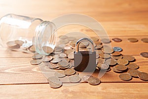 Coins are pouring from the piggy bank and the lock is on them. saving savings concept