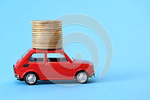 Coins on red miniature car