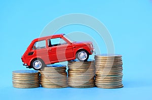 Coins on red miniature car