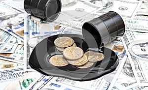 Coins in spilled crude oil on background of dollar bills. Business concept