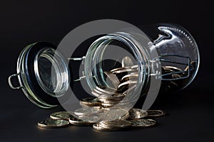 Coins spilling out jar