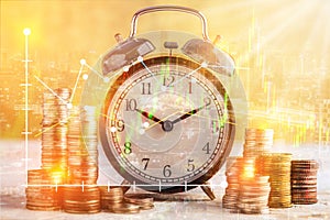coins stack and alarm clock on golden background business concept overlay with financial graph stock with night street view