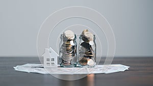 Coins stack with mini house on wooden table, home loan, Save money concept, Property investment, house loan, reverse mortgage,