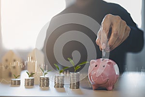 Coins stack and pink piggy with mini wood house model from model on wood table, Planning buy Real Estate, Planning to buy property