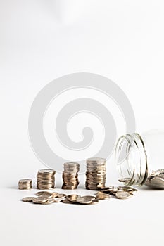 Coins stacked up next to an empty jar with a label on for pension fund. Pension, financial, savings, economy, investment concept