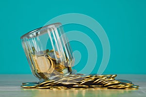 Coins stacks and gold coin money in the glass jar on table with