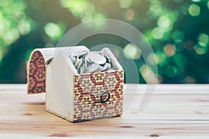 Coins in Treasure Chest indicate savings to buy a home and business growth. planning savings money of coins to buy a home