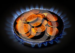 Coins of Ukraine lie on the gas burner of the kitchen stove. Expensive gas in Ukraine. Saving money