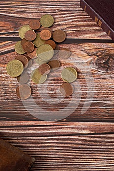 Coins on wooden background with holy bible book and wallet, vertical shot, copy space, top view, Christian tithing concept