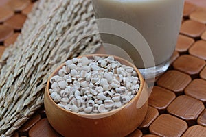 Coix lacryma-jobi, boiled in a glass on a brown background