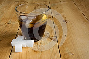 Cola with ice and lemon with sugar cube