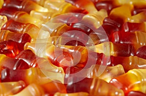 Cola flavored gummy jellies in the shape of cola bottles,background image. Horizontal.