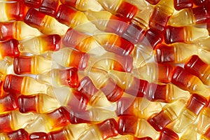 Cola flavored gummy jellies in the shape of cola bottles,background image. Top view.