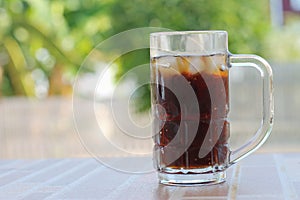 A cola in a glass with a blurred background