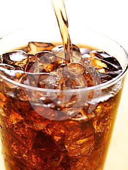 Cola in glass cup with soft drink splash