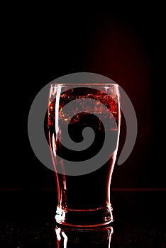 Cola glass with ice cubes and droplets, isolated on black background