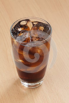 Cola glass with ice cubes on wood table