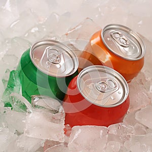 Cola and lemonade beverages in cans on ice photo