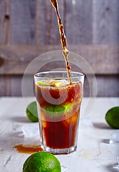 Cola that pour in glass with ice, lime and rum