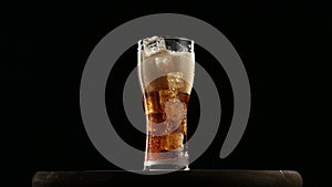 Cola pouring in glass with ice. Glass of cold coke with ice cubes.